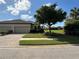 Tan two-car garage villa with lush landscaping and paved driveway at 8191 Varenna Dr, Sarasota, FL 34231