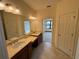 Elegant bathroom featuring double sinks and a view into a bedroom at 8191 Varenna Dr, Sarasota, FL 34231