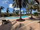 Community pool with lounge chairs and palm trees at 8191 Varenna Dr, Sarasota, FL 34231