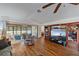 Living room with hardwood floors, large TV, and access to screened porch at 57 Sandstone Cir, Venice, FL 34293