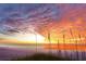 Gorgeous beach view during a vibrant sunset with colorful clouds, ocean and tall vegetation in the foreground at 1055 Beach Rd # B-302, Sarasota, FL 34242