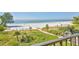 Expansive beach view from a balcony, showcasing the white sands, lush greenery, and tranquil ocean at 1055 Beach Rd # B-302, Sarasota, FL 34242