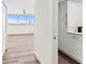 Hallway with light walls and wood-look tile floors, leading to bedrooms and laundry area at 1055 Beach Rd # B-302, Sarasota, FL 34242