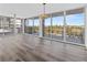 Bright living room with wood floors, modern lighting, and sliding glass doors to the balcony at 1055 Beach Rd # B-302, Sarasota, FL 34242