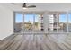 Bright living room with wood floors and sliding glass doors leading to a balcony at 1055 Beach Rd # B-302, Sarasota, FL 34242