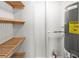 Utility room featuring wooden shelving, a water heater, and a fire extinguisher at 1055 Beach Rd # B-302, Sarasota, FL 34242