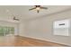 Bright primary bedroom with wood floors, ceiling fans, and sliding glass doors to the backyard at 1782 White Orchid Ct, Sarasota, FL 34235