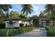 Modern home exterior features a sleek design, two-car garage, and landscaped yard at 1802 Field Rd, Sarasota, FL 34231