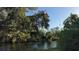 Scenic water view showing lush vegetation and a tranquil pond under a clear blue sky at 1802 Field Rd, Sarasota, FL 34231