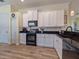 White kitchen with black appliances, granite countertops, and light flooring at 4139 63Rd E Ter, Sarasota, FL 34243