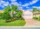 Single-story home with attached garage, lush landscaping, and brick paver driveway at 4139 63Rd E Ter, Sarasota, FL 34243
