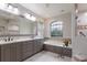 Bright bathroom with a large mirror, soaking tub and step-in shower at 8223 Regents Ct, University Park, FL 34201