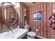 Unique bathroom with patterned wallpaper, oval mirror, and pedestal sink at 8223 Regents Ct, University Park, FL 34201