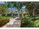 Exterior of building featuring awning, mature trees, and lovely landscaping at 8223 Regents Ct, University Park, FL 34201