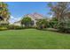 Beautiful home with lush landscaping, a well-manicured lawn, and lovely curb appeal on a sunny day at 8223 Regents Ct, University Park, FL 34201