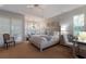Serene main bedroom with plantation shutters, neutral tones, and a tray ceiling at 8223 Regents Ct, University Park, FL 34201