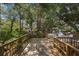Outdoor seating area with wooden deck, lush plants, and string lights at 8223 Regents Ct, University Park, FL 34201