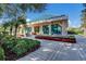 View of the pro shop with blue tile roof and lush landscaping at 8223 Regents Ct, University Park, FL 34201
