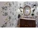 Elegant powder room featuring a dark wood vanity and bird wallpaper at 8223 Regents Ct, University Park, FL 34201