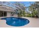 Relaxing kidney shaped pool and spa with screened enclosure at 8223 Regents Ct, University Park, FL 34201