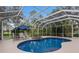 Inviting kidney shaped pool with spa and screened enclosure at 8223 Regents Ct, University Park, FL 34201