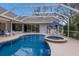 Beautiful kidney shaped pool with spa, screened enclosure, and patio furniture at 8223 Regents Ct, University Park, FL 34201