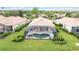 Aerial view of backyard oasis with screened-in pool and spa surrounded by lush landscaping and green lawn at 115 Winding River Trl, Bradenton, FL 34212