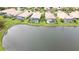Aerial view of several homes with screened-in pools along a lake at 115 Winding River Trl, Bradenton, FL 34212