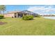 Landscaped backyard features a large lawn and a screened-in pool with views of a peaceful lake at 115 Winding River Trl, Bradenton, FL 34212