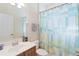 Bathroom with a single vanity, a toilet, and a shower with a blue and green shower curtain at 115 Winding River Trl, Bradenton, FL 34212