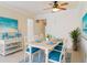 Dining room boasts a white table with seating for six, complemented by blue accents, and a decorative plant at 115 Winding River Trl, Bradenton, FL 34212