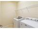 Functional laundry room featuring a washing machine, dryer, and shelving for storage at 115 Winding River Trl, Bradenton, FL 34212