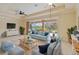 Bright and airy living room with large windows overlooking the screened pool, spa, and a peaceful lake at 115 Winding River Trl, Bradenton, FL 34212