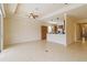 Open living room with tile flooring that transitions into the kitchen with dark wooden cabinets and stainless steel refrigerator at 115 Winding River Trl, Bradenton, FL 34212