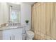 Clean bathroom with granite vanity, mirror, and shower with seashell-themed curtain at 3006 Caring Way # 224, Port Charlotte, FL 33952