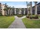 A serene courtyard view with swaying palms and lush green grass at 3006 Caring Way # 224, Port Charlotte, FL 33952