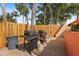 Outdoor grilling area featuring two grills with a wooden fence and tropical landscaping at 3006 Caring Way # 224, Port Charlotte, FL 33952