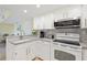 Clean kitchen featuring white cabinets, granite countertops, and stainless steel appliances at 3006 Caring Way # 224, Port Charlotte, FL 33952