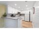 Well-lit kitchen with white cabinets, granite countertops, and modern appliances at 3006 Caring Way # 224, Port Charlotte, FL 33952
