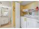Convenient laundry room with a washer, dryer, shelving, and easy access to the bathroom at 3006 Caring Way # 224, Port Charlotte, FL 33952