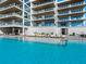 Luxury resort-style pool with surrounding lounge chairs at 4651 Gulf Of Mexico Dr # 402, Longboat Key, FL 34228