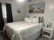 Cozy bedroom featuring a comfortable bed, bedside table, and tasteful nautical-themed artwork at 6006 Hibiscus Dr # 6006, Bradenton, FL 34207