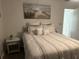 Bedroom featuring neutral bedding, a side table, and a painting over the bed at 6006 Hibiscus Dr # 6006, Bradenton, FL 34207