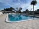 Community pool and seating surrounded by palm trees and landscaping on a cloudy day at 6006 Hibiscus Dr # 6006, Bradenton, FL 34207
