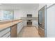 Modern white kitchen with stainless steel appliances and breakfast bar at 800 N Tamiami Trl # 1603, Sarasota, FL 34236