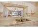 Kitchen with pass-through to living room, white cabinets, and double sink at 9320 Clubside Cir # 2109, Sarasota, FL 34238