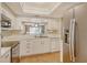 Bright kitchen features white cabinets, stainless steel appliances, and a pass-through to the living area at 9320 Clubside Cir # 2109, Sarasota, FL 34238