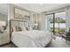 Bright bedroom with plush bed, ensuite access, and sliding glass doors to patio at 9869 Haze Dr, Venice, FL 34292