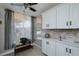 Modern kitchen with white cabinets, stone backsplash and window at 4550 Pinebrook Cir # 103, Bradenton, FL 34209