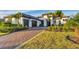 Two-story home with a three-car garage and a brick driveway at 1209 Blue Shell Loop, Sarasota, FL 34240